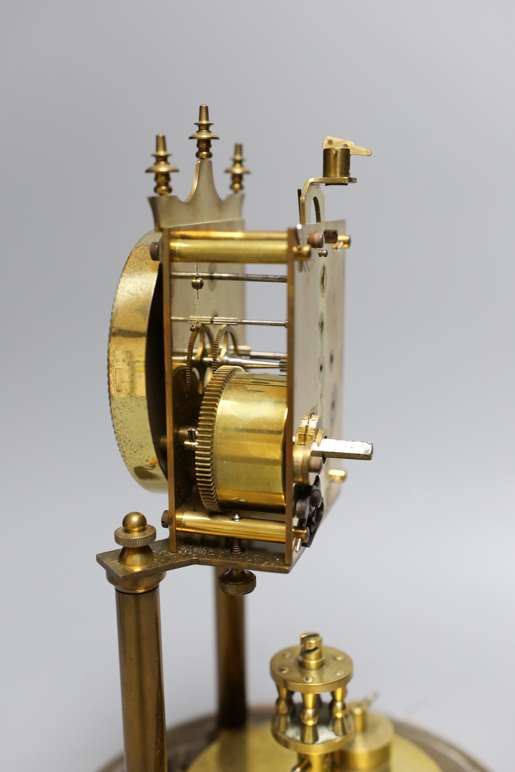 A German 400 day brass mantel timepiece, under a glass dome, 30cm total
